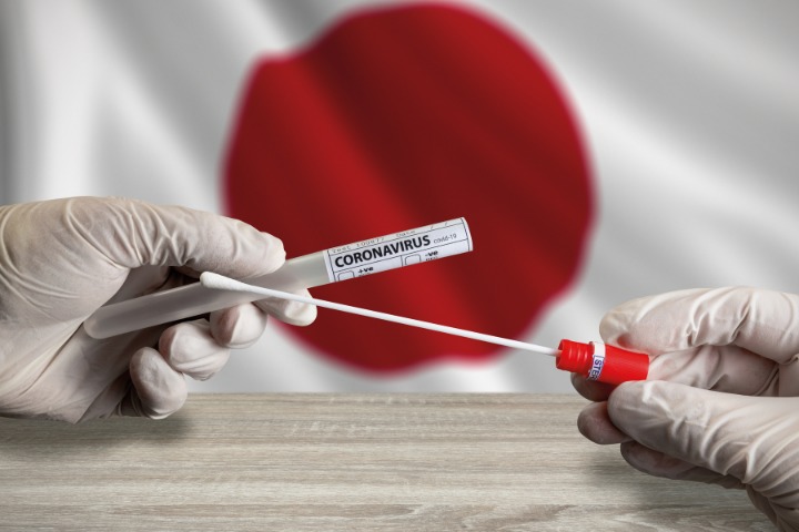 Coronavirus rapid test stick with a background of Japan national flag