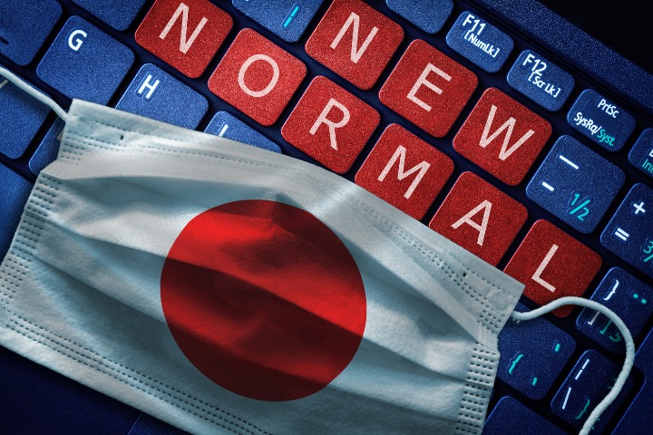 a mask over a keyboard with the words "new normal" spelled 