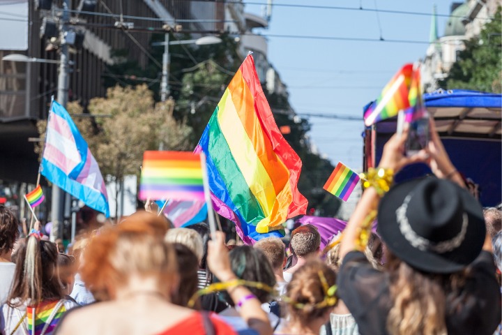 A photo of people holding up rainbow flags for a pride parade
