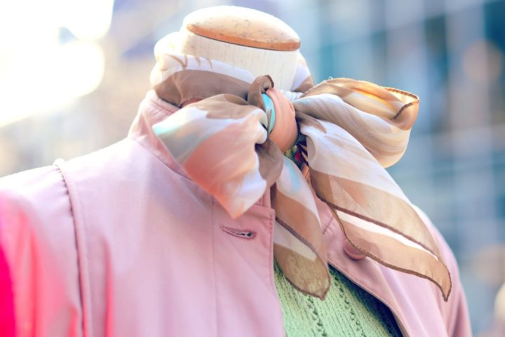 photo of vintage outfit pink bomber jacket and patterened neck scarf tied in a bow on a mannequin