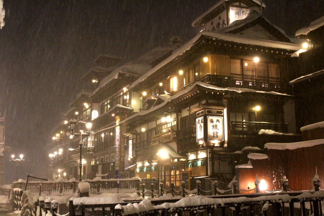 a photo of ginzan onsen main street at night in the snow