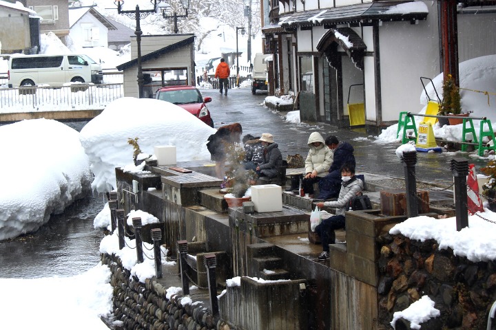 a photo of people enjoying a free foot spa in ginzan onsen