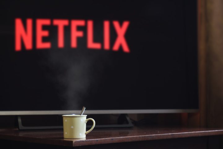 a photo of a cup of tea in front of a TV with the Netflix logo on it