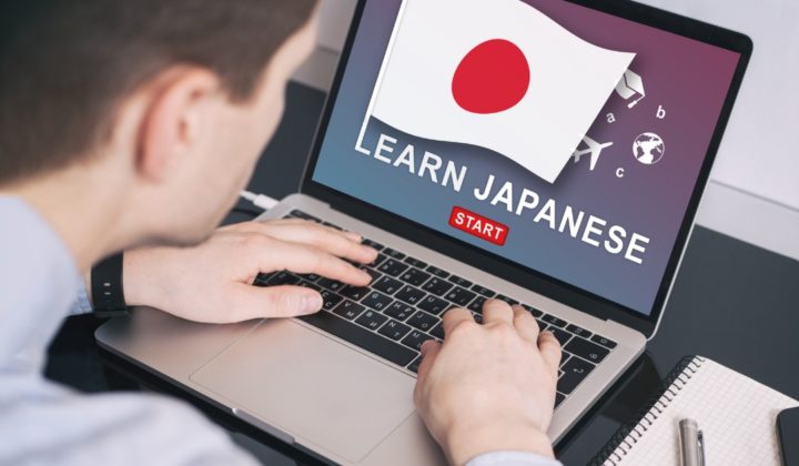 A man learn Japanese from a computer.
