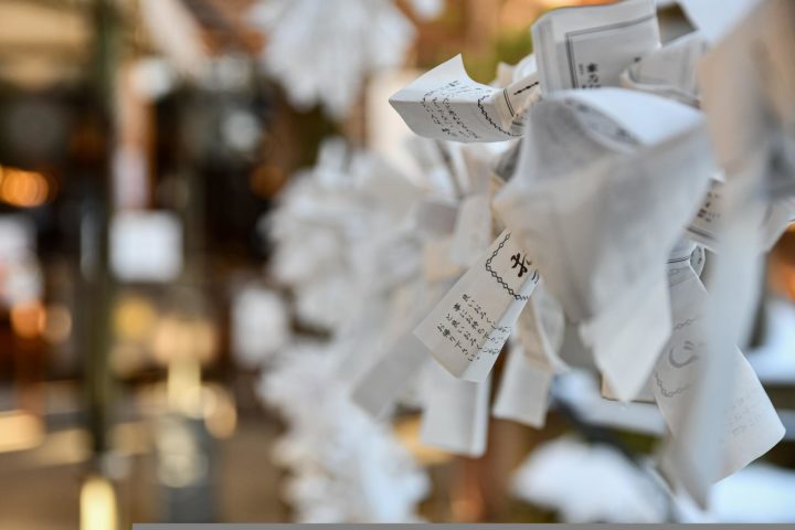 a photo of bad fortune omikuji tied to a temple 