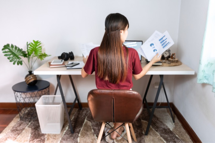 a photo of a japanese woman sat at a desk doing work