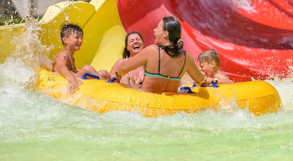 People are laughing and sitting on a swim ring in water parks