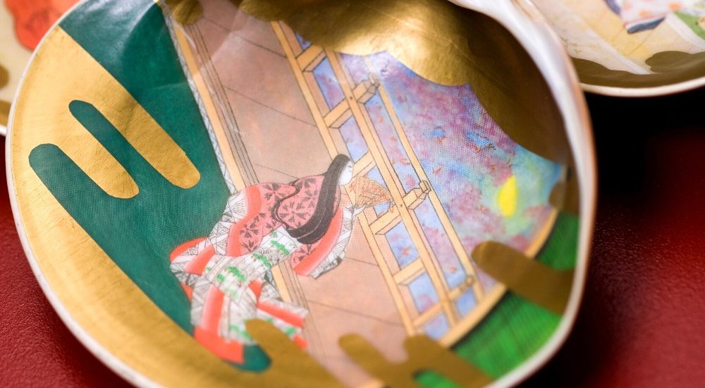 a photo of seashells painted with scenes from the tale of genji