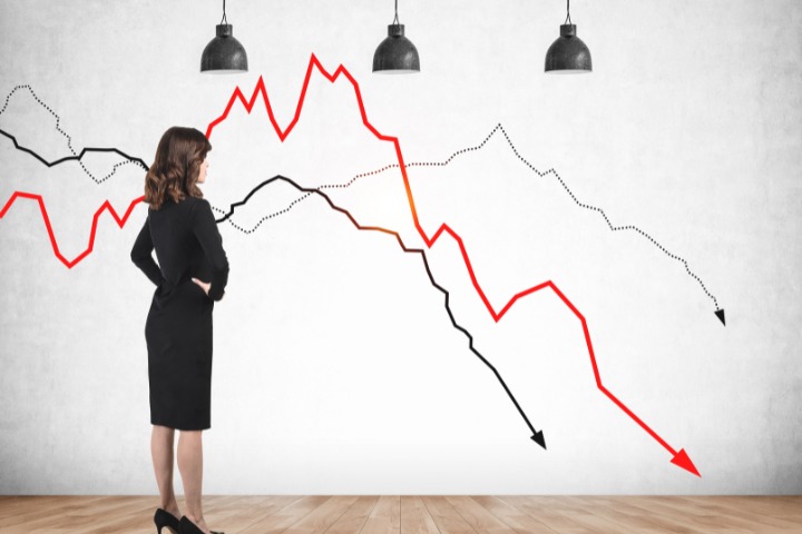 woman standing in front of downward trend on graph