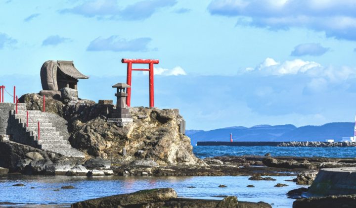 a photo of a torii gate on a small island
