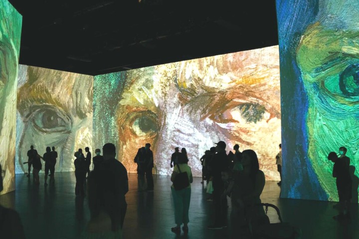 Visitors standing in front of the light instalments at the Vincent Van Gogh art exhibition 