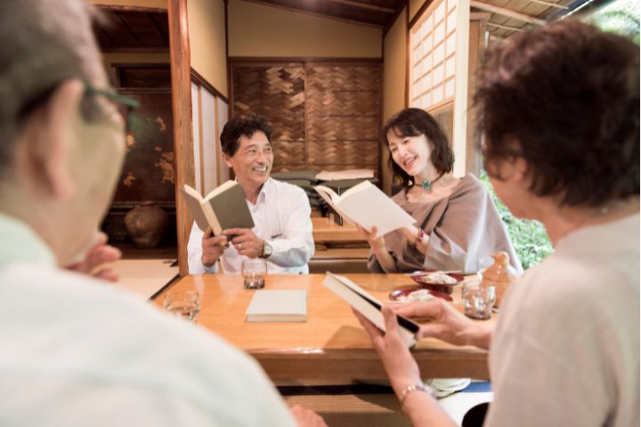 A Group Of People Reading A Japanese Novel