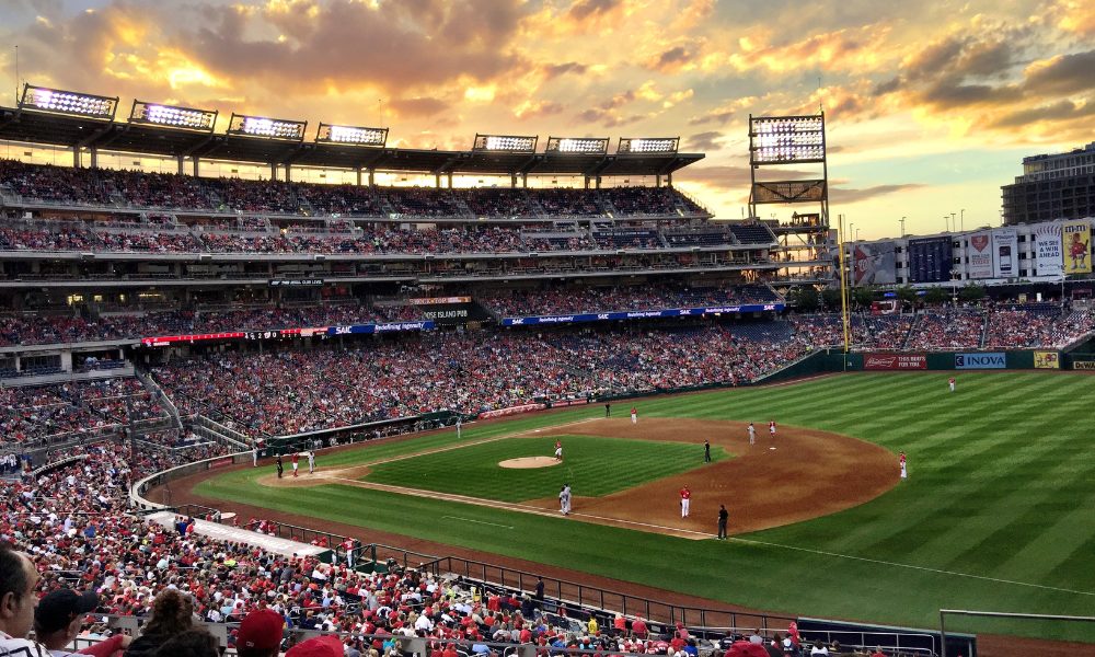 People watching a baseball game from the stands, enjoying the action on a field.