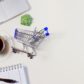a photo of a small trolley, plant, notebook, coffee and laptop representign online shopping in japan