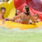 People are laughing and sitting on a swim ring in water parks